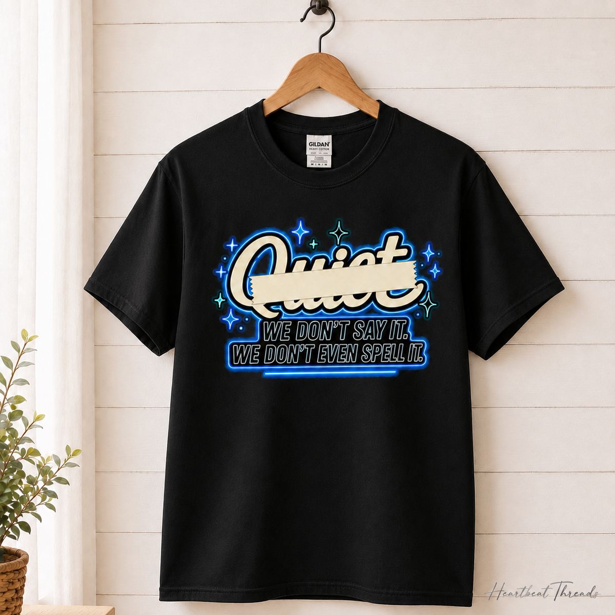 Quiet We Don't Say It We Don't Even Spell It Graphic Tee - neon hanging mockup on black shirt